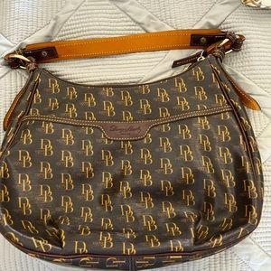 Dooney and Bourk handbag brown in color with red inside.